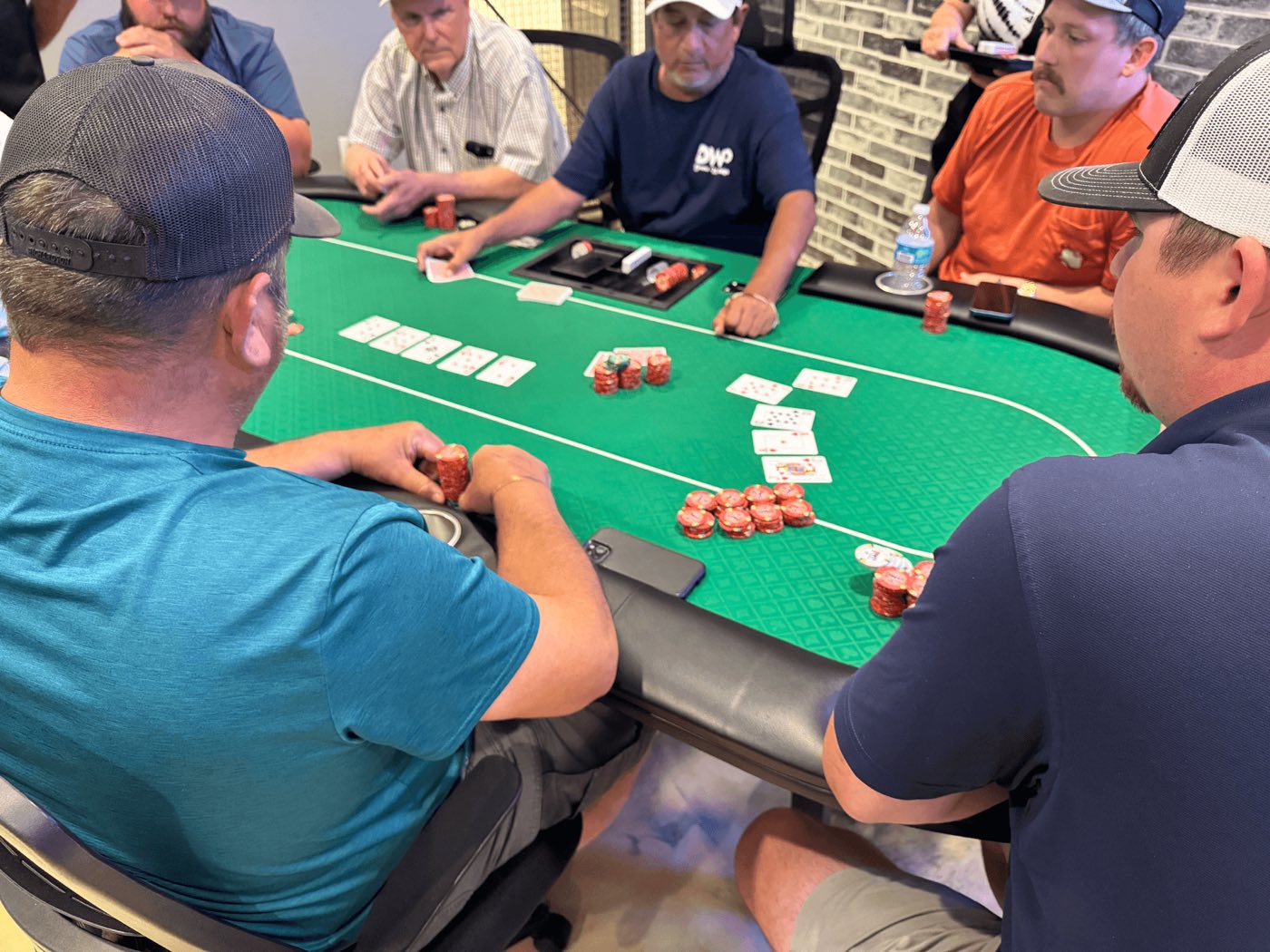 Chips and cards on the felt during a cash game at Deuces Wild