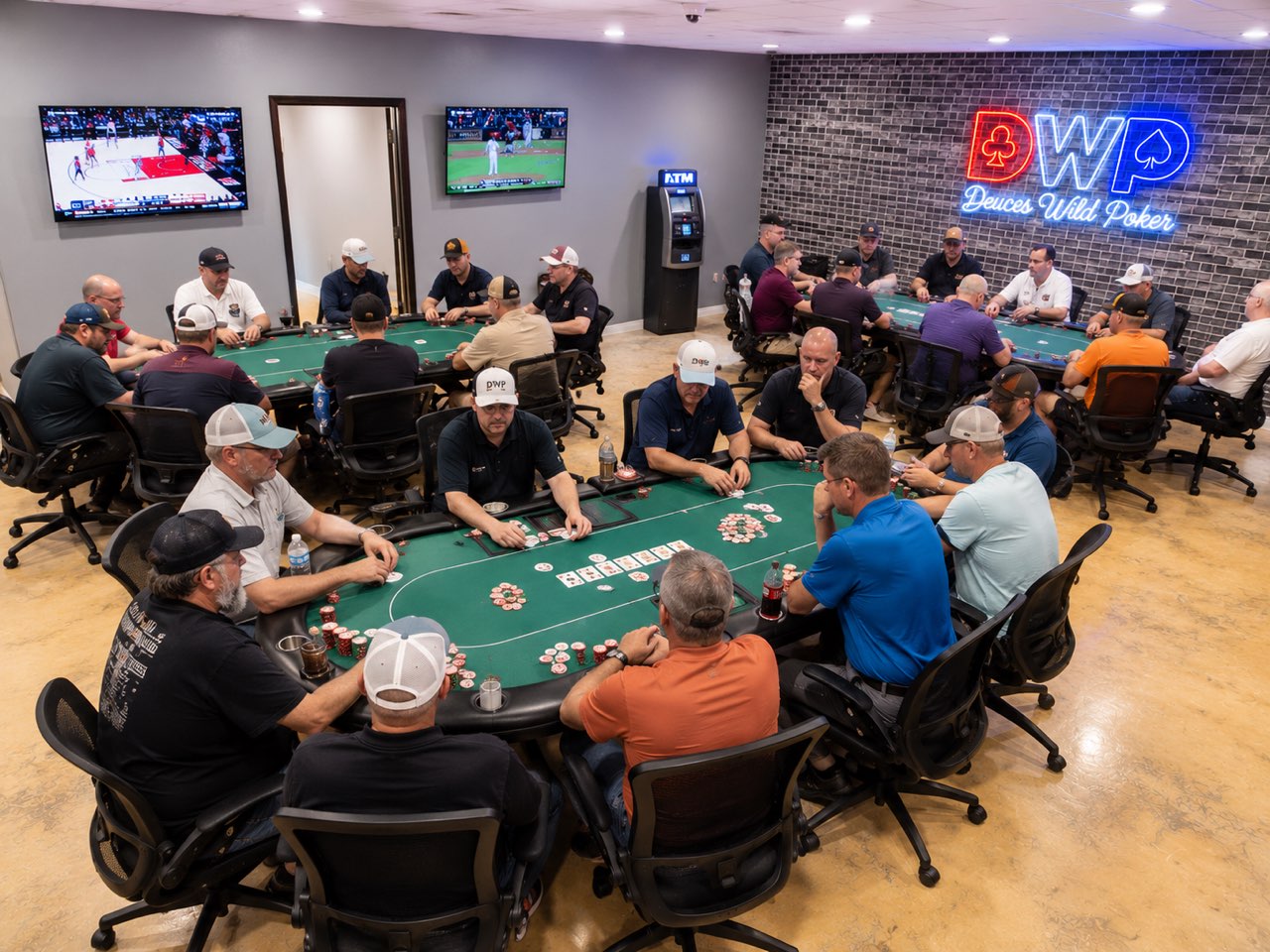 A busy night at Deuces Wild Poker Club — two full tables of players under the DWP neon sign